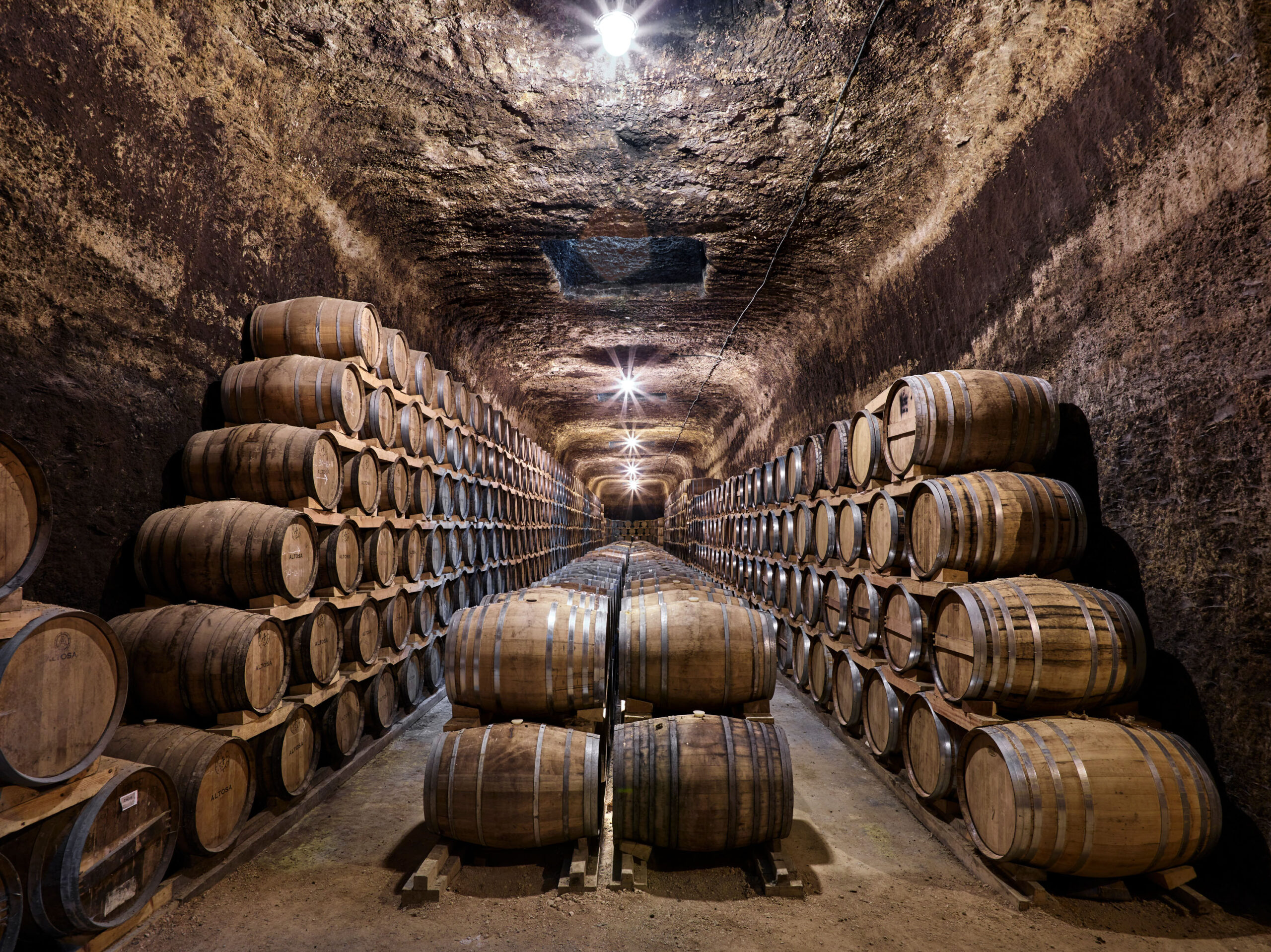 Pasillo de barricas en una bodega manchega